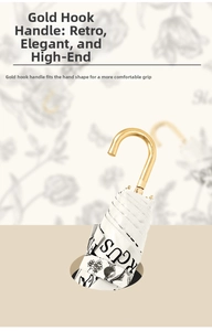 Detail of vintage umbrella with gold curved handle and elegant floral pattern fabric