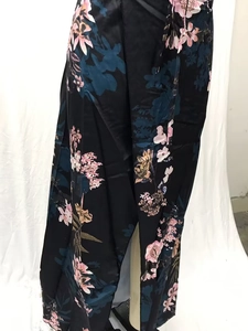 Detail of floral maxi dress with satin finish and tropical print on black fabric