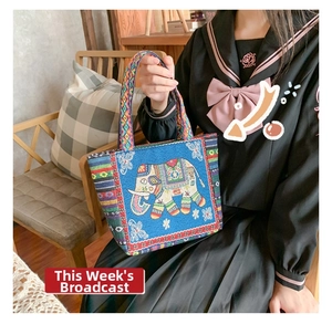 Detailed shot of an ethnic style woven blue tote bag featuring elephant embroidery patterns