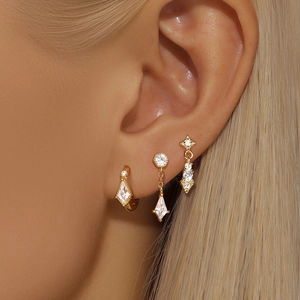 Close-up of gold s925 silver earrings set with pearls and opal stars on a model