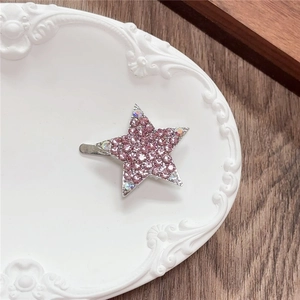 Detailed close-up of a pink rhinestone star hair clip with colorful crystal accents