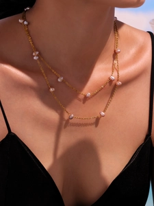 Double-layer gold necklace with natural irregular pink pearls worn by a female model