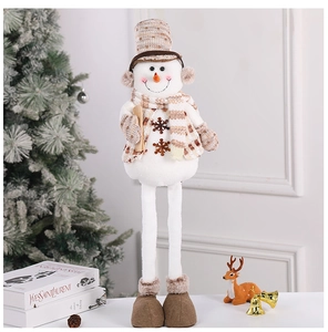 Macro detail of plush snowman doll with brown checkered hat and snowflake embroidery