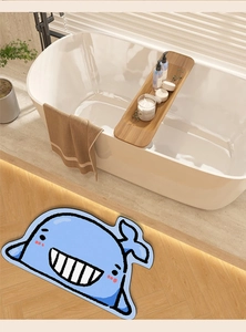 Macro detail of a blue whale-shaped absorbent bath mat on a wooden floor