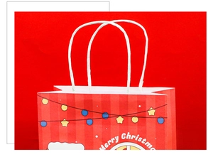 Detail of red Merry Christmas kraft gift bag with white rope handles and festive prints