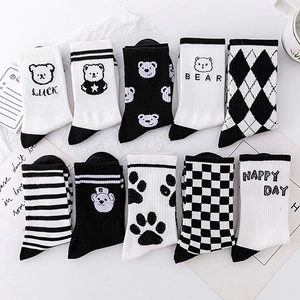 Collection of black and white cotton crew socks featuring bear, grid, and stripe patterns