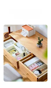 Modular white plastic drawer organizers showing skincare items in a wooden drawer setup