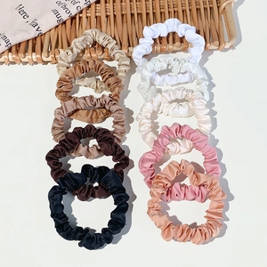 Set di elastici per capelli in raso multicolore con design elastico su sfondo bianco