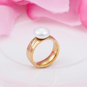 Close-up of golden hammered stainless steel ring featuring a white pearl detail
