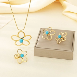 Vue détaillée d'une parure fleurie dorée avec perles turquoises sur fond de soie douce
