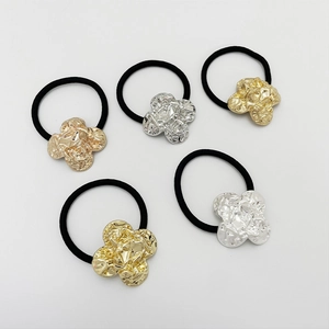 Detail of five elastic hair ties featuring gold and silver hammered metal flower charms