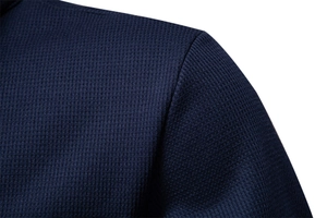 Detailed macro view of the dark blue waffle knit texture and shoulder stitching on the jacket