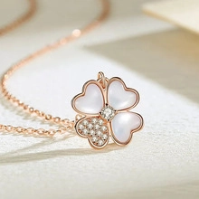 Macro detail of rose gold clover pendant with white mother of pearl and sparkling zircon