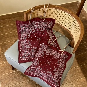 Bohemian paisley tote bag in burgundy with unique colorful beaded handle on a chair