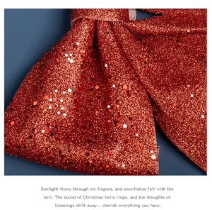 Macro shot of large red glitter Christmas bow featuring shiny sequins and pearlescent texture