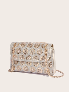Close-up of golden chain strap and luxury rhinestone clutch with sunflower detail