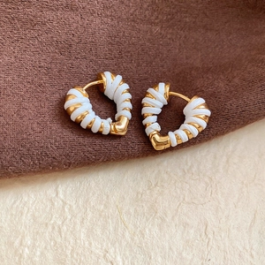 Gros plan détaillé de boucles d'oreilles cœur en or 18 carats avec fil blanc enroulé
