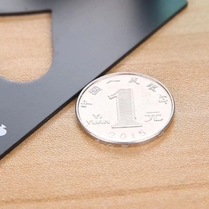 Macro shot of Ace of Spades card bottle opener next to a coin for size reference