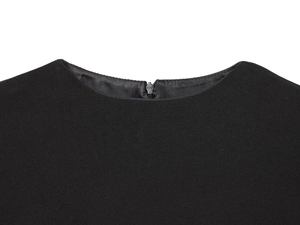 Détail du col rond et de la fermeture éclair invisible sur une robe noire sans manches