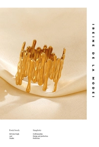 Detail shot of golden liquid metal ring with lava flow texture on silk fabric