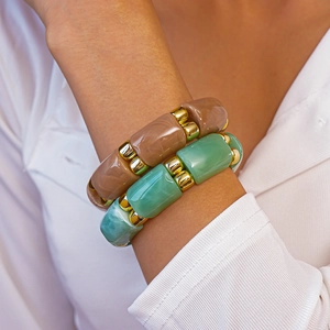 Detailed shot of amber and turquoise resin bracelets with metallic gold spacers