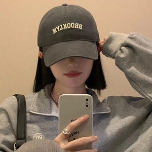 Detailed close-up of dark grey cotton baseball cap with white BROOKLYN embroidery