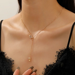 Detail of gold tennis racket necklace with zircon badminton pendant on female model