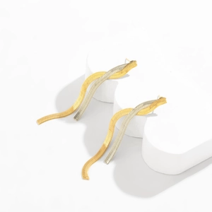 Detail of two-tone gold and silver snake chain fringe earrings with wavy metal tassels