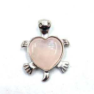 Detailopname van zilveren schildpad hanger met hartvormige roze kristallen steen