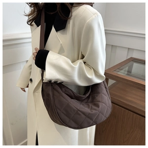 Close-up of coffee brown quilted nylon crossbody bag with textured stitching details