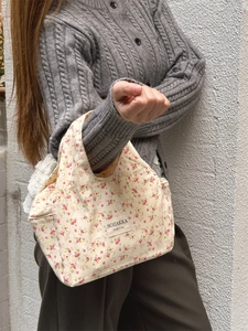 Detail of floral lunch bag featuring a fabric brand label on cream canvas material