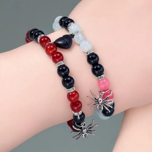 Halloween magnetic couple bracelets with red, black, and white beads and spider charms