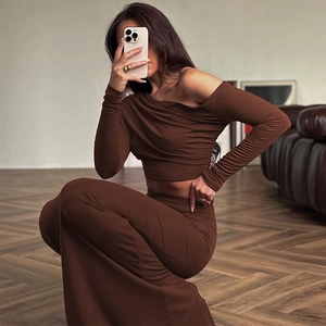 Dettaglio del crop top marrone con spalle scoperte e della gonna aderente coordinata