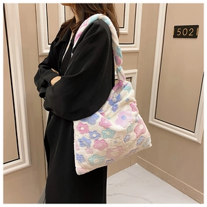 Detail view of soft plush crossbody bag with colorful flower patterns worn by a model