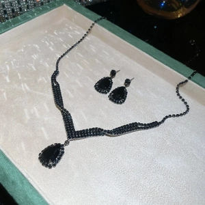 Detail of black water-drop pendant necklace and matching teardrop earrings set