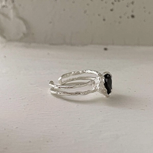 Macro shot of irregular double-layered S925 silver ring with a black heart zircon stone