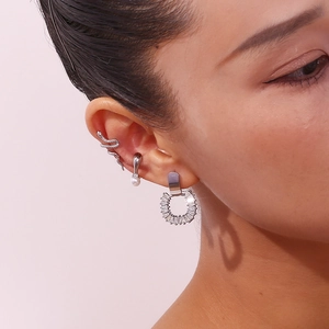 Detailed close-up of a silver snake ear cuff set with a pearl drop and zircon stud