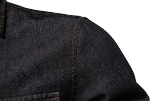 Macro detail of reinforced shoulder stitching on dark denim shirt with contrast orange thread