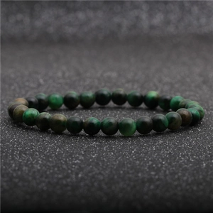 Macro shot of green tiger eye stone bracelet beads with polished texture and natural patterns
