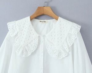 Detail of white blouse featuring double-layer hollow lace collar and lantern sleeves