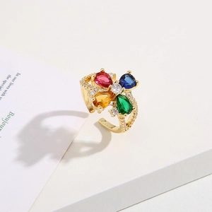 Squisito anello floreale dorato con pietre colorate a goccia e pavé di zirconi su sfondo