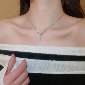 Close-up of sparkling zircon snake-shaped Y-necklace on a model neck with shimmery details