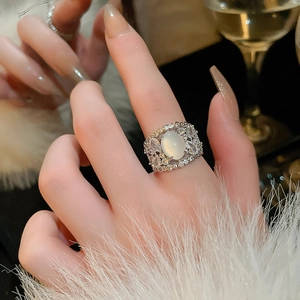 Detailed view of vintage hollow-out ring with oval opal and sparkling white zircons