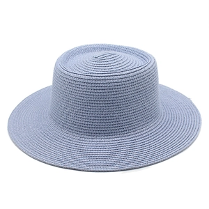 Detail view of the fine spiral weave texture on the light blue straw sun hat