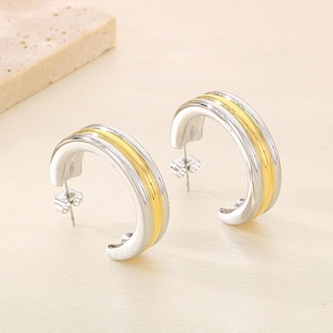 Détail de boucles d'oreilles en C en acier inoxydable avec finition polie bicolore
