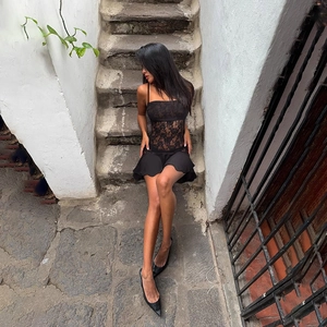 Détail de la taille en dentelle florale transparente sur une mini robe noire ajustée
