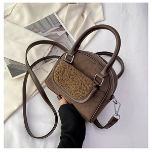 Detail of plush tote bag showing suede texture and faux shearling pocket with leather straps