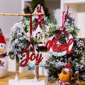 Detailed view of Joy and Noel wooden glitter Christmas ornaments on a festive tree.