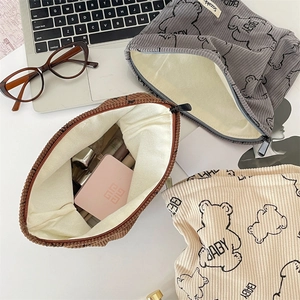Detailed internal view of corduroy makeup bag filled with cosmetics and soft fabric lining
