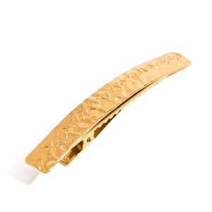 Golden stainless steel hair clip with textured leaf pattern design in a minimalist style